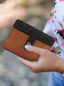 Detail of checkered quilted leather coin purse with silver snap button in hand