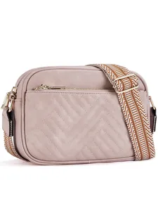 Detail of pink chevron quilted crossbody bag with adjustable geometric pattern strap