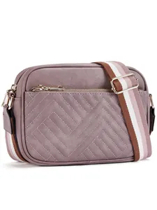 Detail of dusty pink crossbody camera bag featuring lychee grain and wide stripe strap