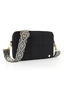 Detailed view of black quilted waterproof crossbody bag with geometric jacquard strap
