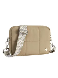 Close-up of khaki quilted puffer crossbody bag with ethnic style woven shoulder strap