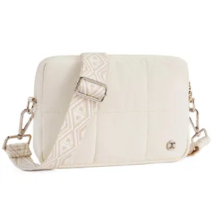 Close-up of quilted crossbody bag featuring a geometric patterned strap and silver hardware