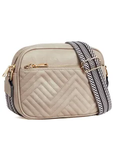 Detail of beige chevron quilted crossbody bag with stylish black and white woven strap