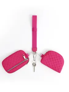Detail view of pink quilted nylon wristlet pouch with silver hardware and lanyard strap