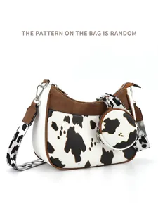 Detail view of crescent crossbody bag with cow pattern strap and matching coin purse