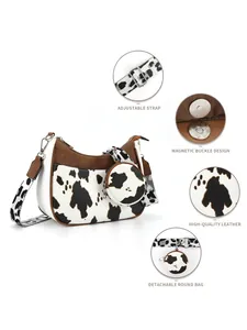 Detail view of cow print shoulder bag showing magnetic buckle and adjustable strap