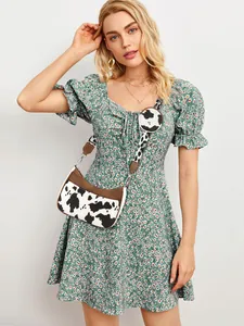 Fashion set featuring green floral puff sleeve dress with cow print crossbody bag detail