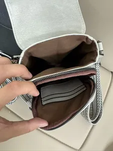 Dettaglio mini borsa a tracolla con trama litchi e scomparti interni per carte