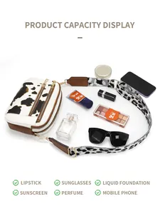 Internal storage view of cow print crossbody bag with makeup and smartphone essentials
