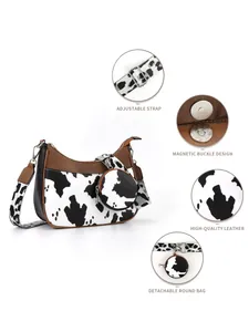Detail of adjustable strap and hardware on a high-quality cow print crescent crossbody bag