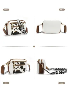 Crossbody bag detail with cow print patterns, multiple zippers and adjustable strap