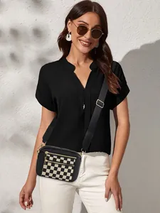 Détail du sac bandoulière à damier avec double zip doré et large sangle ajustable