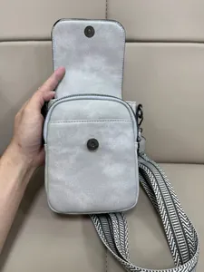 Dettaglio mini borsa a tracolla per cellulare con patta magnetica e tracolla regolabile