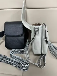 Dettaglio della mini borsa a tracolla con tasche a zip e tracolla in tessuto chevron