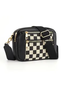 Détail du sac à bandoulière à damier avec fermetures dorées et sangle réglable