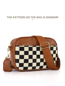 Close-up of checkerboard canvas and brown pebbled leather bag with gold hardware detail