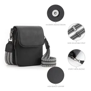 Dettaglio mini borsa a tracolla in pelle nera con ampia tracolla geometrica regolabile