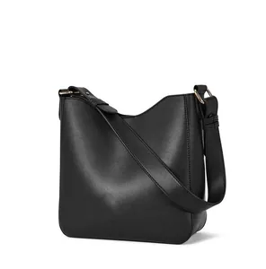 Detail shot of black minimalist shoulder bag showing fine leather texture and golden metal buckle