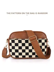 Detail of checkered crossbody camera bag with wide adjustable canvas strap and zip closure