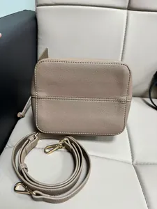 Detailed macro view of pebble-grain khaki PU leather and elegant gold metal hardware