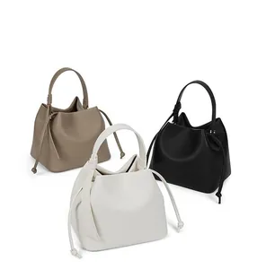 Minimalist bucket handbags in khaki, white, and black with drawstring details