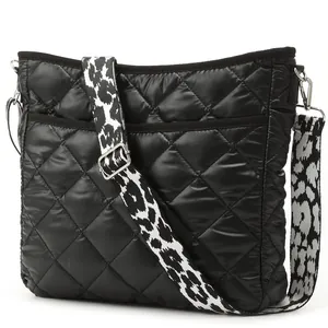 Detail of black quilted nylon crossbody bag with stylish leopard print wide shoulder strap