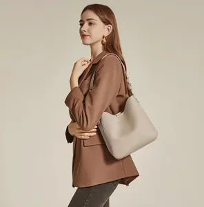 Detail of silver metallic buckle on oatmeal leather hobo bag with a soft grainy texture