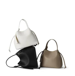 Three bucket bags in white, black and taupe showing pebbled leather and drawstring details