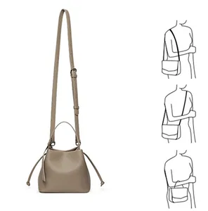 Detailed view of khaki PU leather bucket bag showing top handle and drawstring closure
