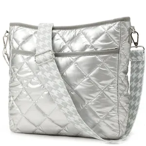 Detail of silver quilted crossbody bag with stylish houndstooth pattern wide strap