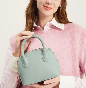 Détail d'un sac coquillage vert menthe avec texture cuir et fermeture éclair