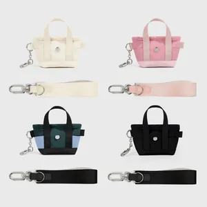 Griglia dettagliata di mini borse in nylon in avorio, rosa, verde e nero con cinturino