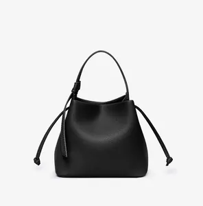 Close-up of black lychee grain PU leather bucket bag with decorative drawstrings