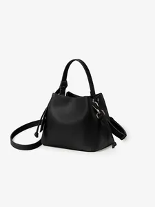Close-up of black litchi pattern leather bucket bag with knotted drawstrings and handle