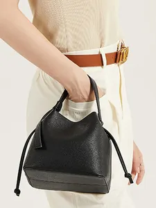 Close-up of black lychee grain PU leather bucket bag with drawstrings and sleek texture