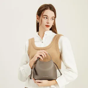 Close-up of gray bucket bag with litchi texture and branded logo detail