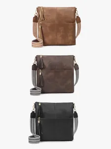 Vertical display of vintage crossbody bags in brown and black with woven straps