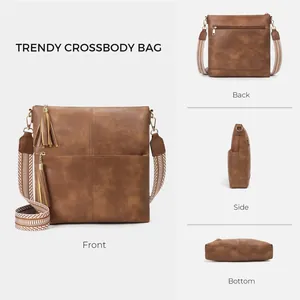 Brown vintage messenger bag with totem woven strap and dual tassel charms in detail