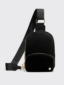 Dettaglio borsa a tracolla in nylon nero con cerniera dorata e ampia cinghia regolabile
