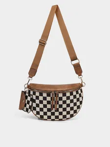 Detail of checkerboard crossbody bag with brown faux leather trim and mini earphone pouch
