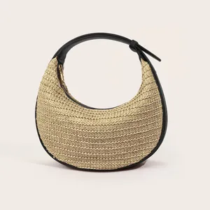 Detail of minimalist woven half-moon hobo bag with black leather trim and gold zipper