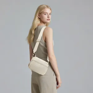 Nahaufnahme der cremeweißen Nylon-Umhängetasche mit Doppelreißverschluss und Golddetails