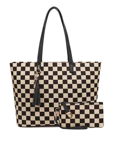 Détail du motif damier du sac cabas avec pompons et finitions métalliques dorées