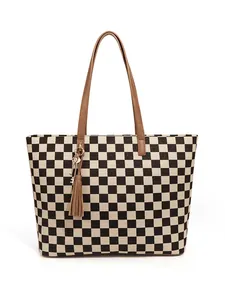 Détail du sac cabas à damier avec poignées en cuir marron et pendentif gland décoratif
