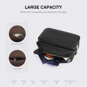 Internal compartments and texture detail of black leather crossbody bag with dual zippers