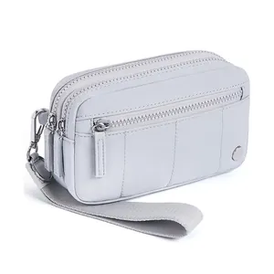 Détail du sac de poignet en nylon gris clair à multicouches avec trois fermetures