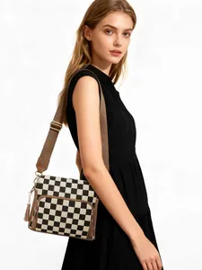Detail view of jacquard crossbody bag with checkerboard pattern and brown strap