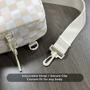Detail of adjustable woven strap and plastic D-ring buckle on checkerboard bag