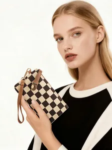 Detail of checkered pattern wallet with brown leather wrist strap and golden buckle clasp