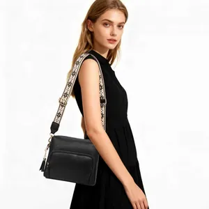 Black pebbled leather crossbody bag with floral jacquard strap and tassel accent